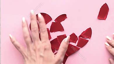 Collect broken heart. The female hand collects the heart torn to pieces