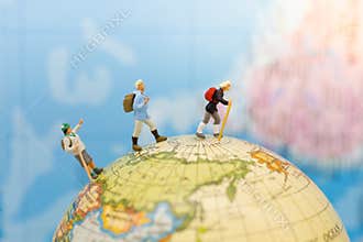 Miniature people: Group traveler backpack stand and walking on world map. Image use for travelling or business trip concept