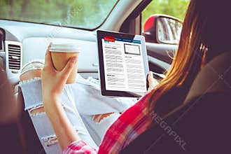 Girl with tablet in her hands in the car