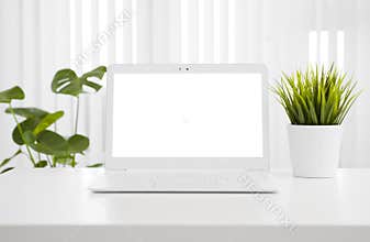 White laptop computer mockup with blank screen on office table