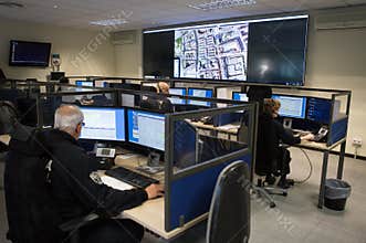 Police officers at surveillance control center room wide