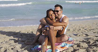 Cuddling happy couple on beach
