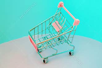 Shopping cart. Empty supermarket trolley on violet background. 90s style glitch effect