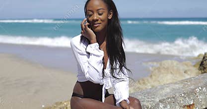 Black woman talking on phone on stone