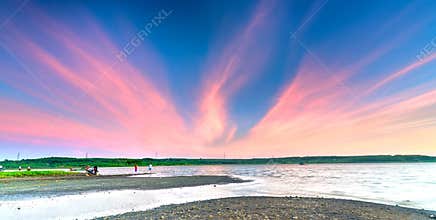 Couple fun welcome sunset on the riverside with impressive clouds in sky,