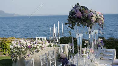 Beautiful table setting with crockery and flowers for a party, wedding reception or other festive event. On the shores