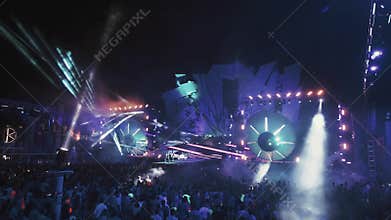 Ukraine, Popovka Kazantip -AUGUST 5, 2013:DJ on main stage lighting crowd of people dancing around on musical dance show