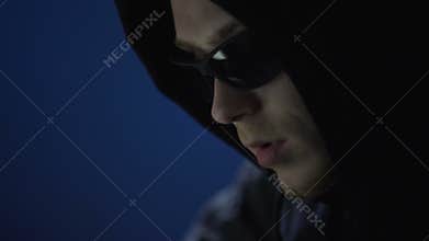 Hands of computer hacker in black gloves typing on laptop to hack banking system