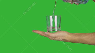 Male arm hand holding glass and pouring drinking water from plastic bottle. Alpha channel, keyed green screen.