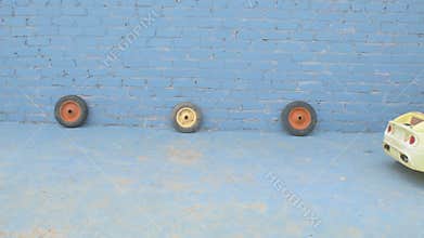 Funny kids in superhero`s masks roll their little brother on yellow car. Boys are happy together and dream of adventures, travels,