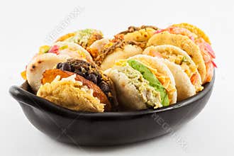 Arepas with assorted fillings served in a black ceramic dish