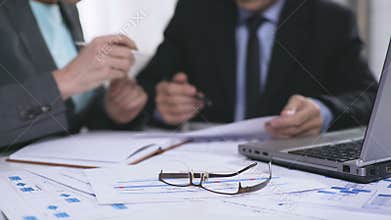 Bank representatives analyzing statistics reports financial charts, paper work