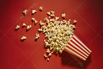 Spilled popcorn on a red background, cinema, movies and entertai