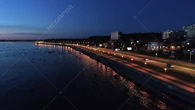 Aerial Shot of Scene with Driving Cars on the Coastline Road on the Night
