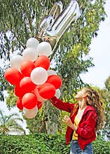 A teenage girl with birthday balloons