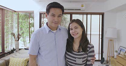 Portrait of happy couple standing inside new home with keys