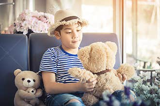 Lovely moment of asian cute boy playing with doll.