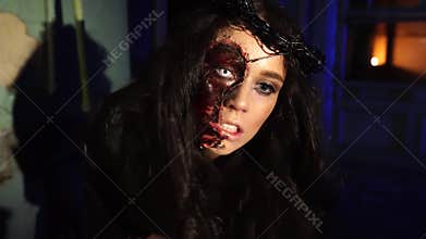 Scary vampire girl with blood sticks knife in her mouth