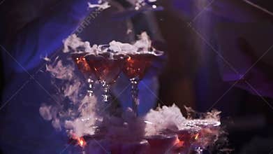 People taking drinks from pyramid of glasses with champagne