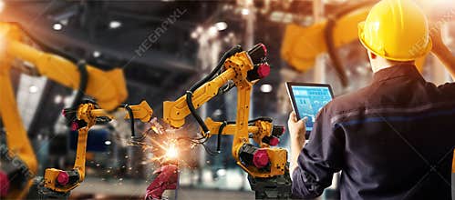 Engineer check and control welding robotics automatic arms machine in intelligent factory automotive industrial with monitoring sy