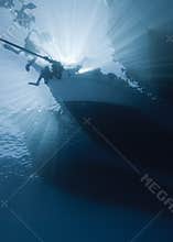 Silhouette of divers and dive boat.