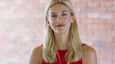 Smiling young female near brick wall