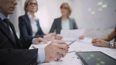 Overworked male office worker sighs at meeting, occupational burnout, stress