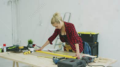 Woman using spirit level on workshop desk