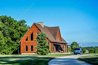 Log Cabin Home with Blue Vehicle