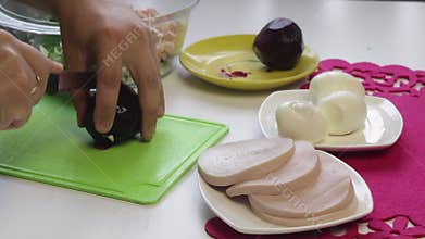 The cook cuts the boiled beets on a cutting board.