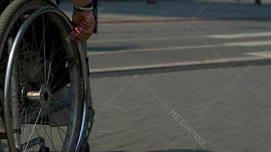 Closeup of girl hand turning wheels on his wheelchair