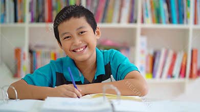 Male preteen student smiling in the library