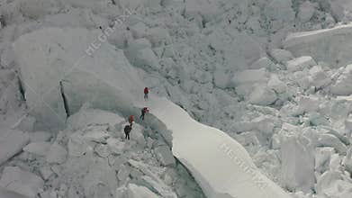 Drone footage of people climbing mount Everest, massive icy cliffs, extreme, 4k