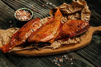 Smoked fish on wooden cutting board. river bass fish smoked or salted. delicious snacks for beer