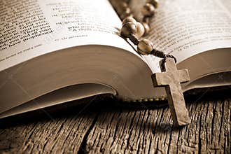 Wooden rosary on the open Bible