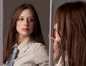 Woman in Tie Looking In Mirror