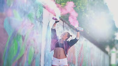 Concept of freedom and creativity. Happy girl spray aerosol paint into air. Creative teenager graffiti artist having fun