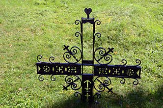 Metal decorative cross in meadow partisan cemetery