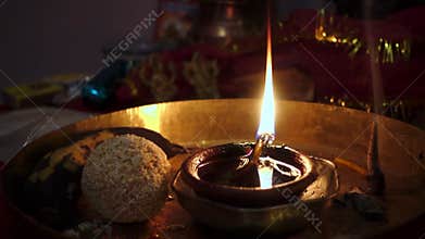 A close up shot of DIYA  clay oil lamp  with burning sticks during a religious ritual in INDIA