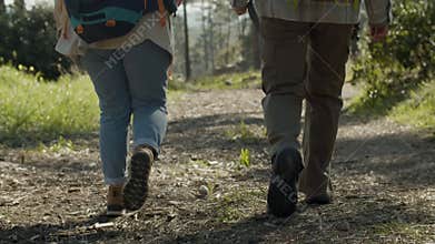 Two people walking along dirt path in national park