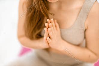 Girl does yoga. Young woman practices asanas on a beige one-ton background.