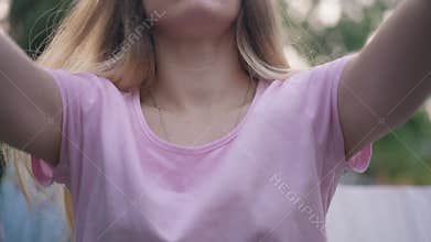Front view young woman shaking clean white cloth in slow motion covering camera. Portrait of Caucasian housewife hanging