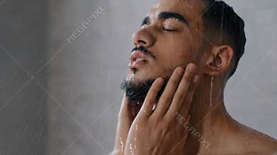 Arab indian man bearded guy naked male washes head with shampoo washing hair face and beard in bathroom showering in at