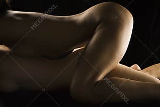 Nude women lying together.
