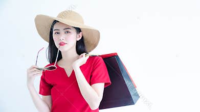Asian woman with sunglasses and hat are shopping in the summer she is using a credit card and enjoys shopping. Nice charming girl