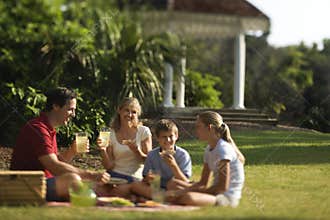 Family having picnic in park.