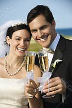 Bride and groom holding champagne.