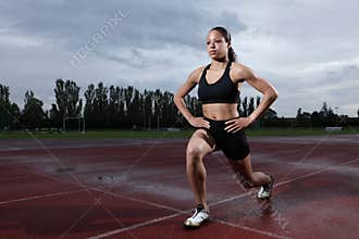 Lunge exercise for quadriceps by athlete on track