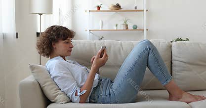 Carefree middle aged beautiful happy woman typing on smartphone.