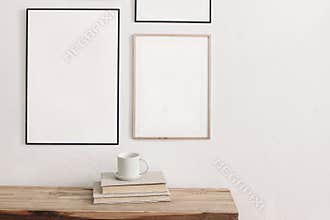 Set of black portrait picture frame mockups. Wall art gallery. Cup of coffee on pile of books on old wooden bench, table